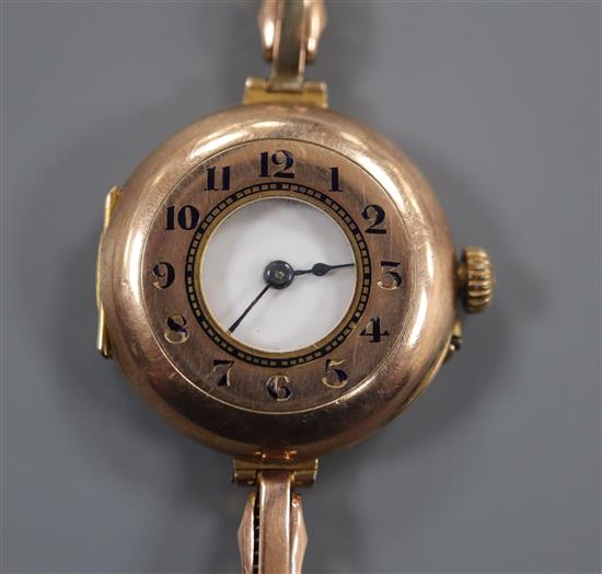 A ladys early 20th century 9ct Rolex half hunter manual wind wrist watch, on a yellow metal flexible strap.